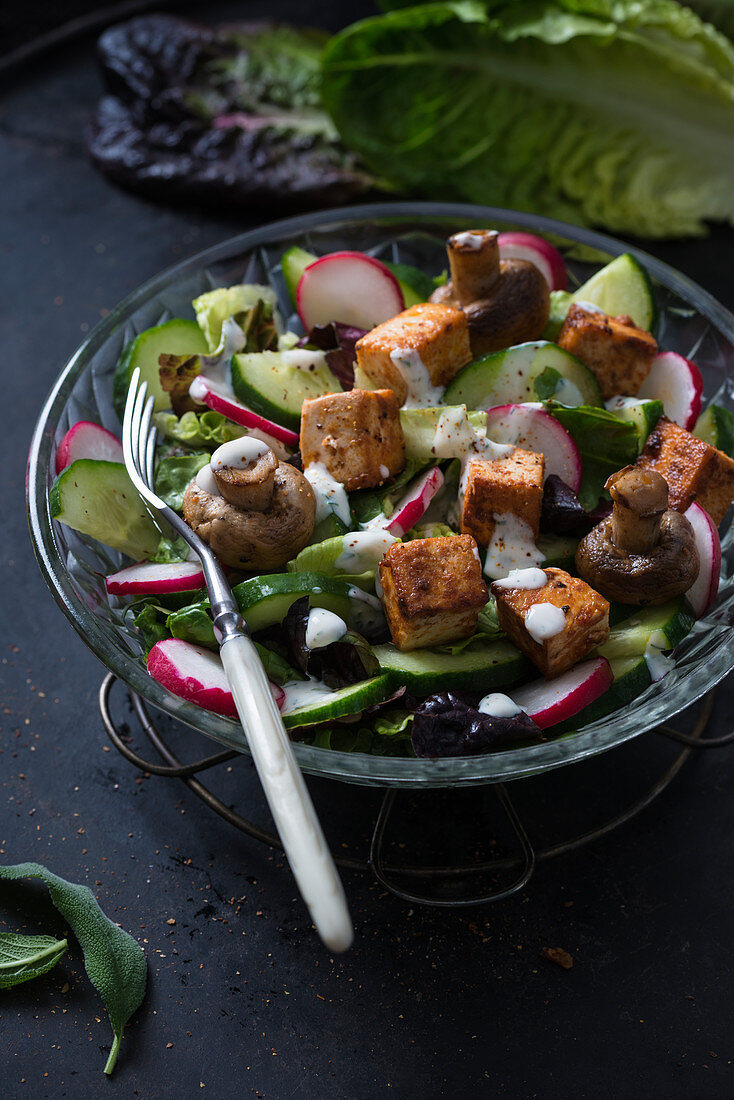 A salad with fried tofu, mushrooms and herb dressing