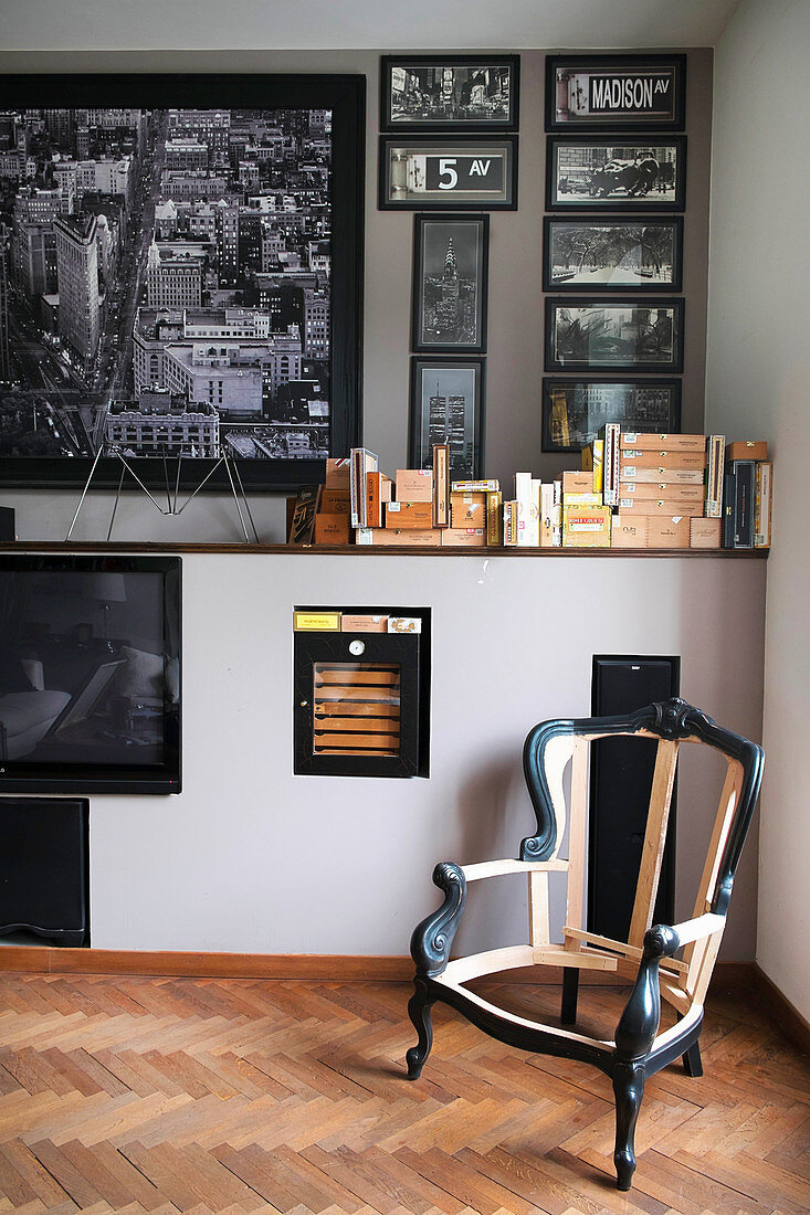 Antiker Stuhlrahmen in Zimmerecke, schwarz-weiße Fotosammlung an der Wand