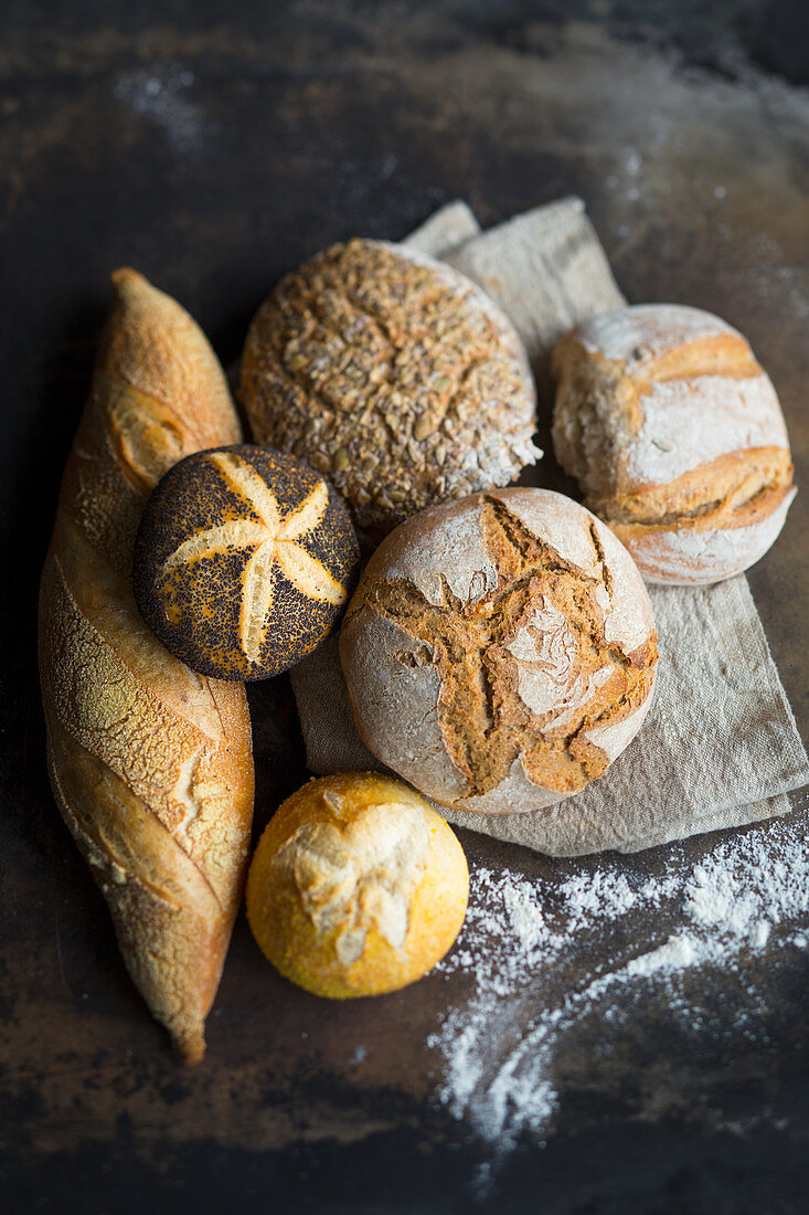 Arrangement of baguettes, bread, wholemeal bread, a white bread roll and a poppy seed roll