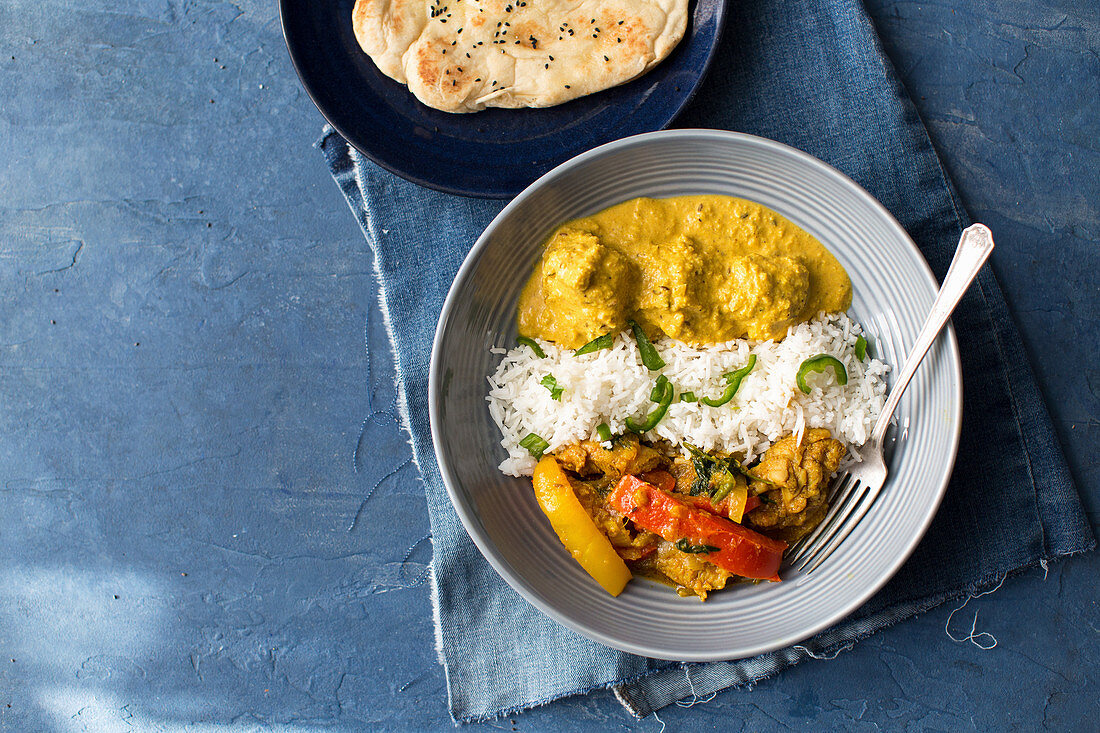 Chicken jalfrezi and chicken korma with rice and naan bread (India)