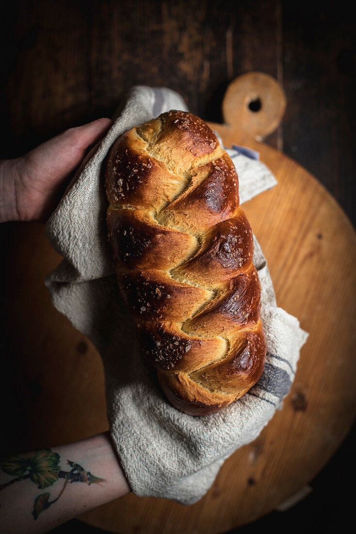 Hände halten Challah-Brot (jüdische Küche)