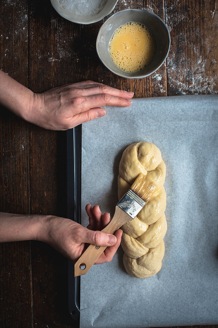 Challah bread (Jewish cuisine) being made: yeast dough being brushed with butter
