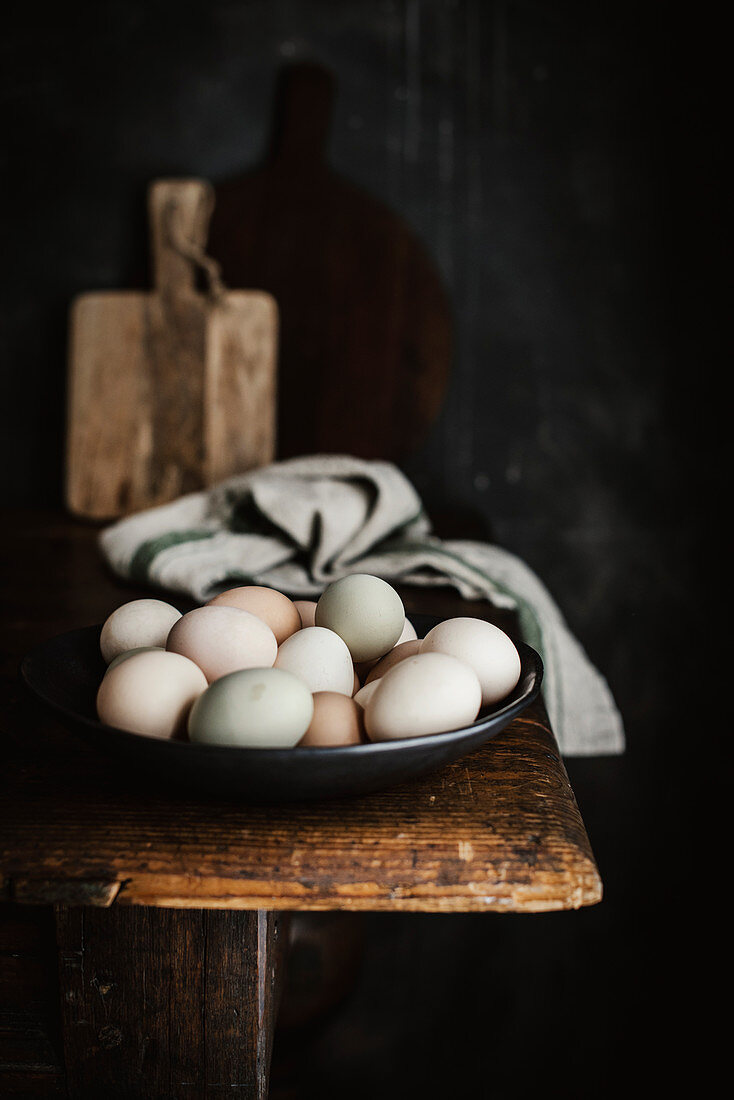 Mit Naturfarben gefärbte Eier in Schale auf Holztisch