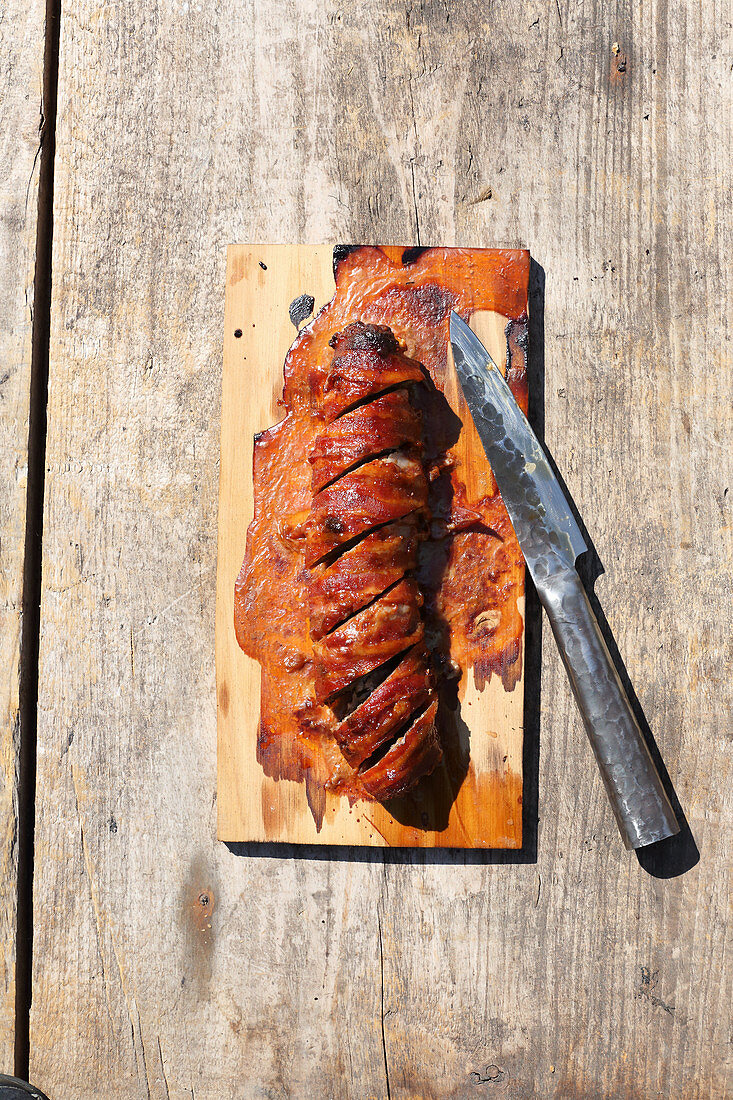 Gegrillte Hackfleisch-Bacon-Päckchen mit Jalapenos auf Holzplanke