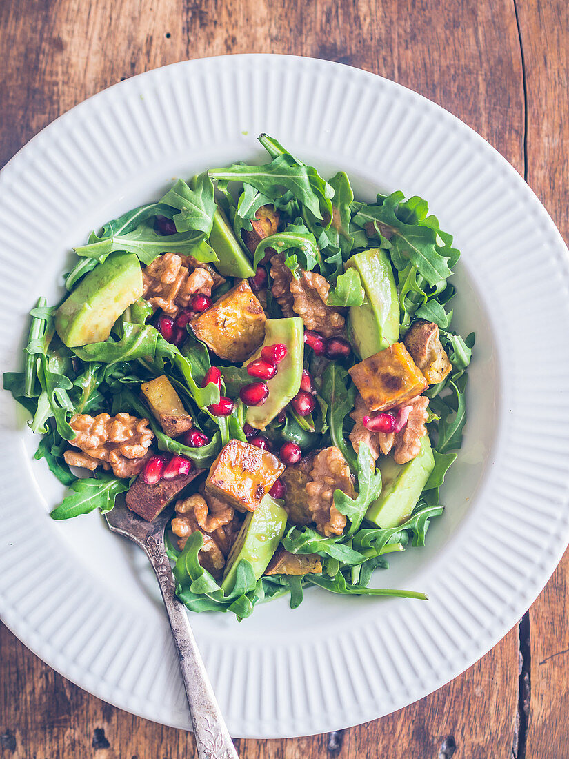 Arugula salad with organic sweet potatoes, avocado, grilled nuts and pomegranate