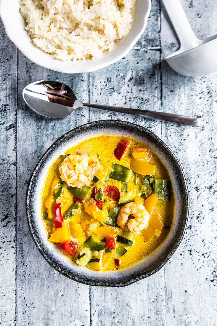 Thai-Curry aus Paprika, Zuckerschoten, Zucchini, Kokosmilch und Garnelen, dazu Reis