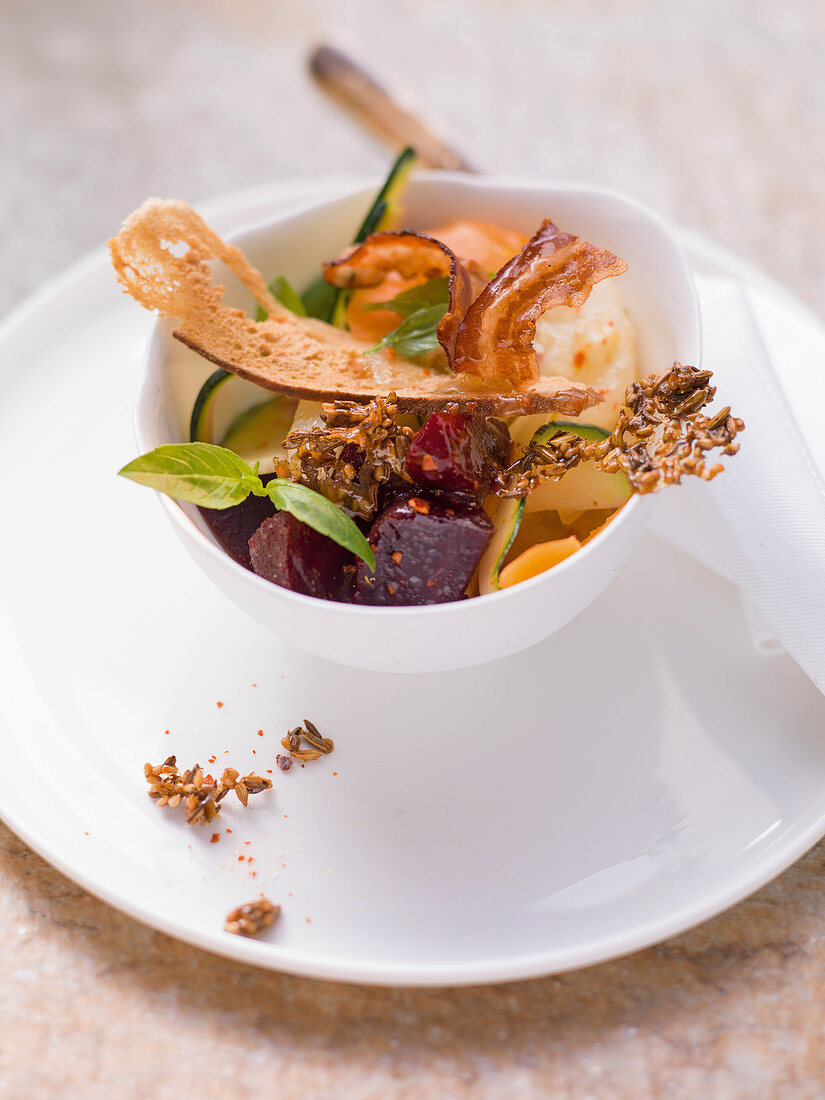 Vegetable salad with sesame brittle, bacon and pretzel chips