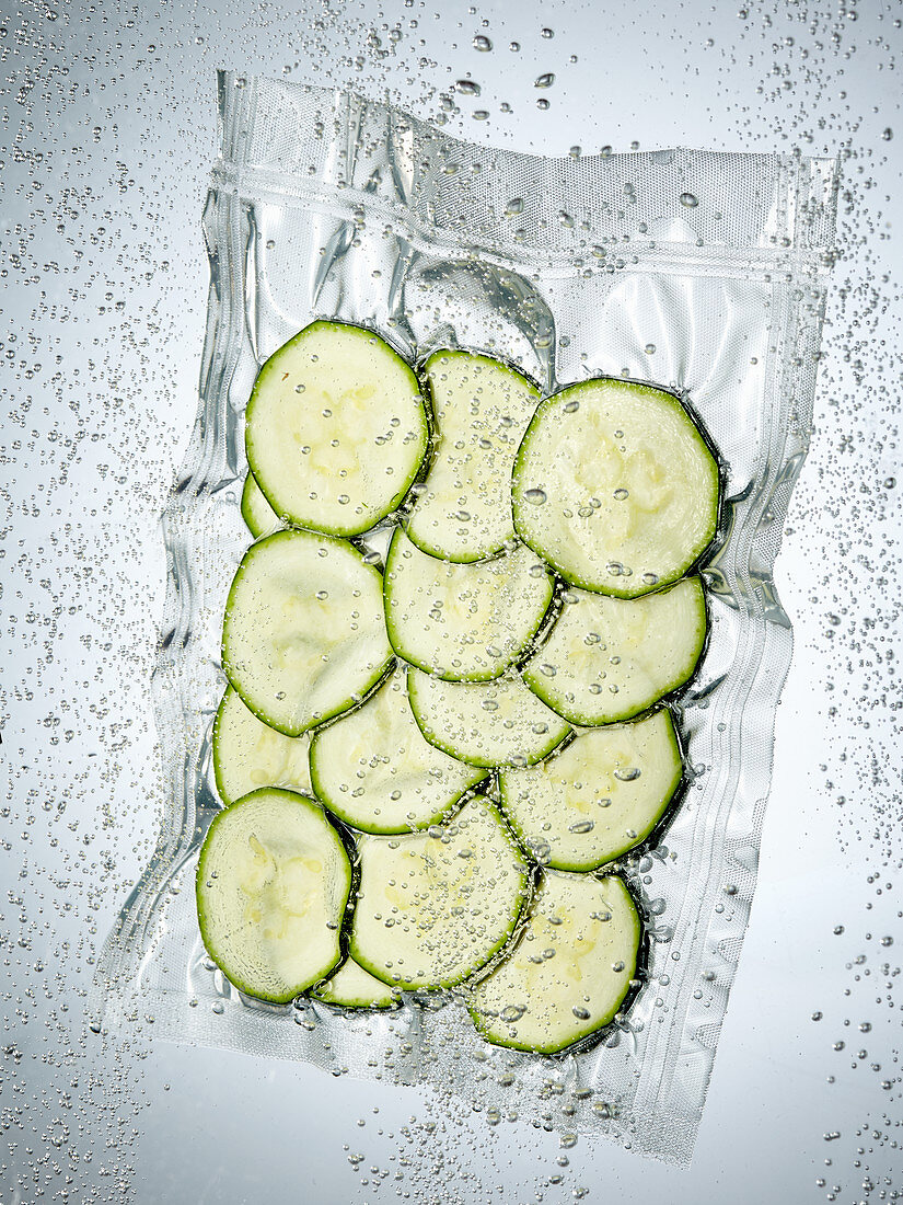 Courgette slices in a sous vide bag – License Images – 12468325 ❘ StockFood