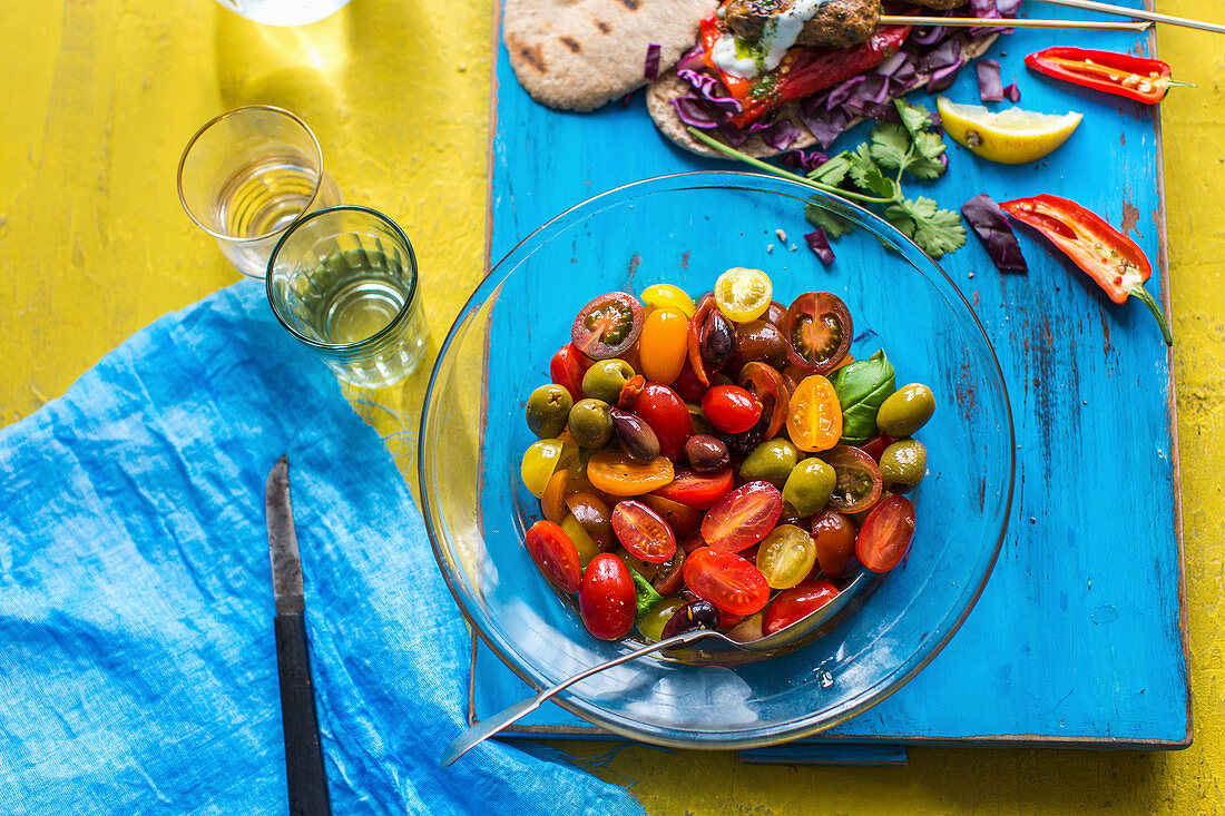 A tomato salad with olives and basil