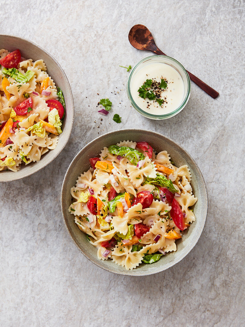 Farfalle salad with tomatoes, peppers, parsley, onion and a yoghurt dressing