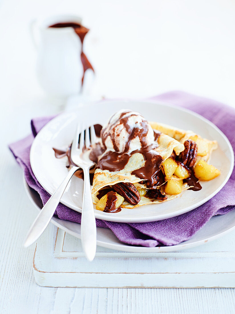 Crepes with pears, pecan nuts, chocolate sauce and ice cream