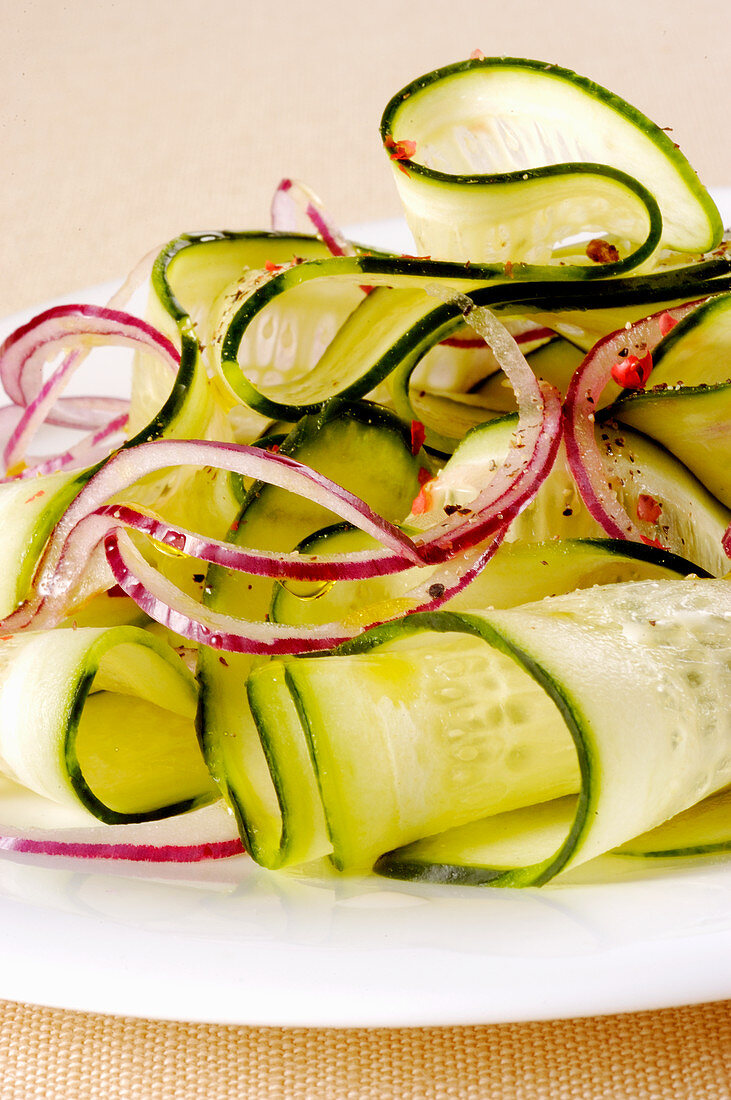 Cucumber carpaccio with red onions (close-up)