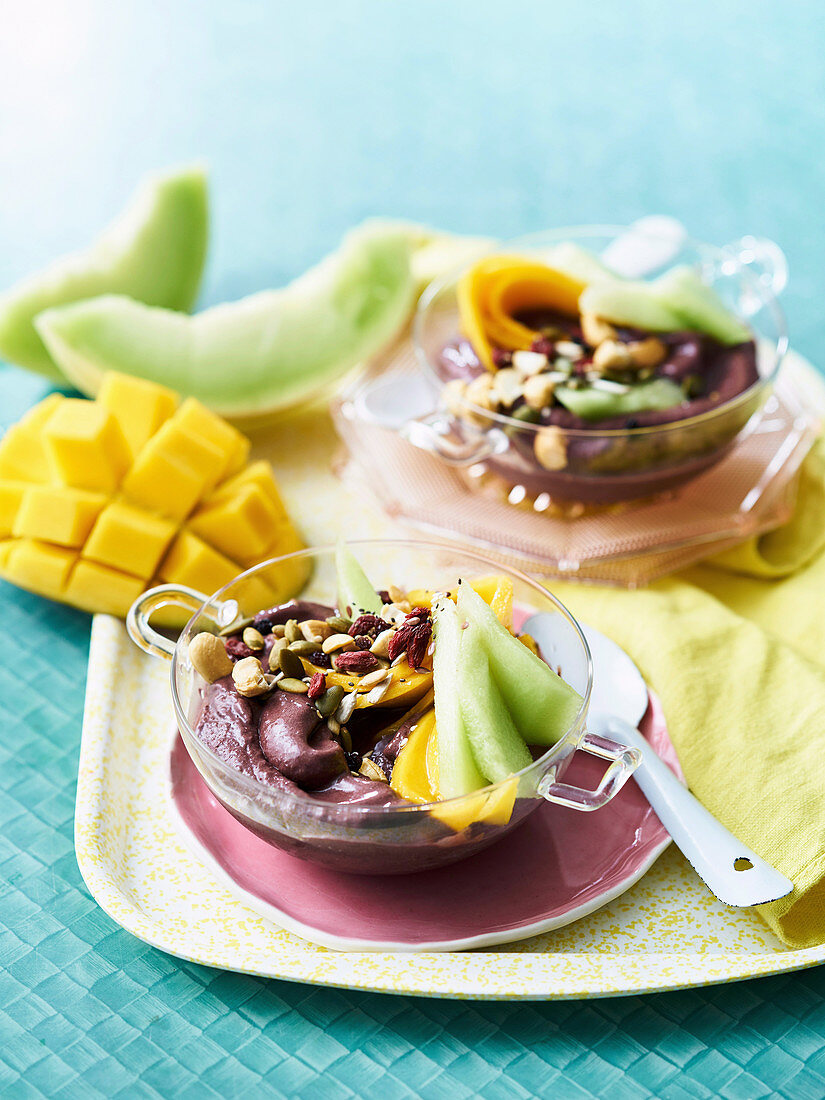 Superfood breakfast bowl with acai, nuts, banana, yogurt and honeydew melon