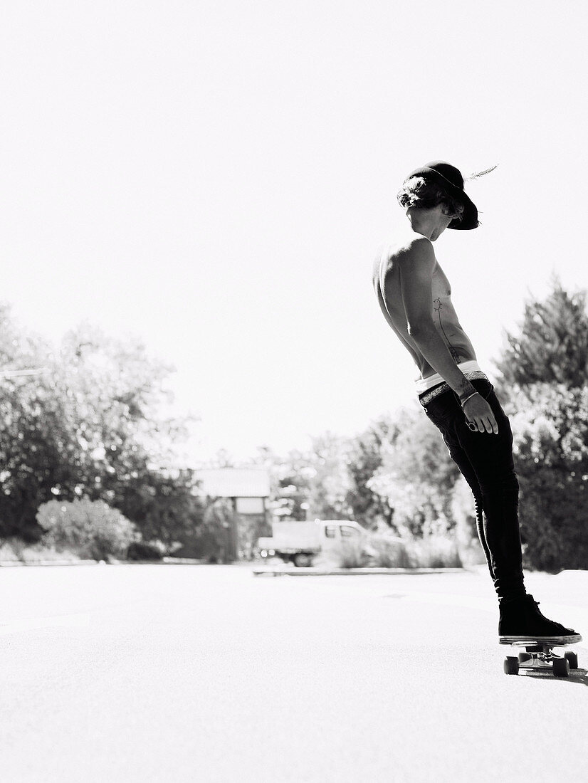 A young man with a skateboard (black-and-white shot)