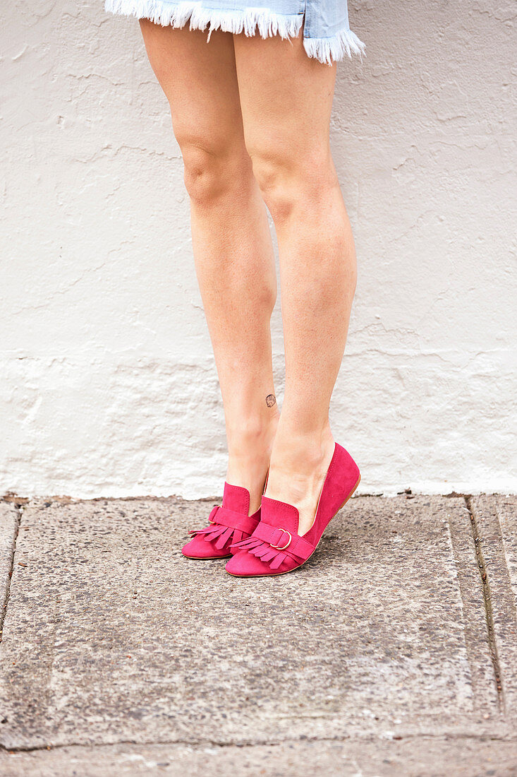 A woman wearing pink moccasins