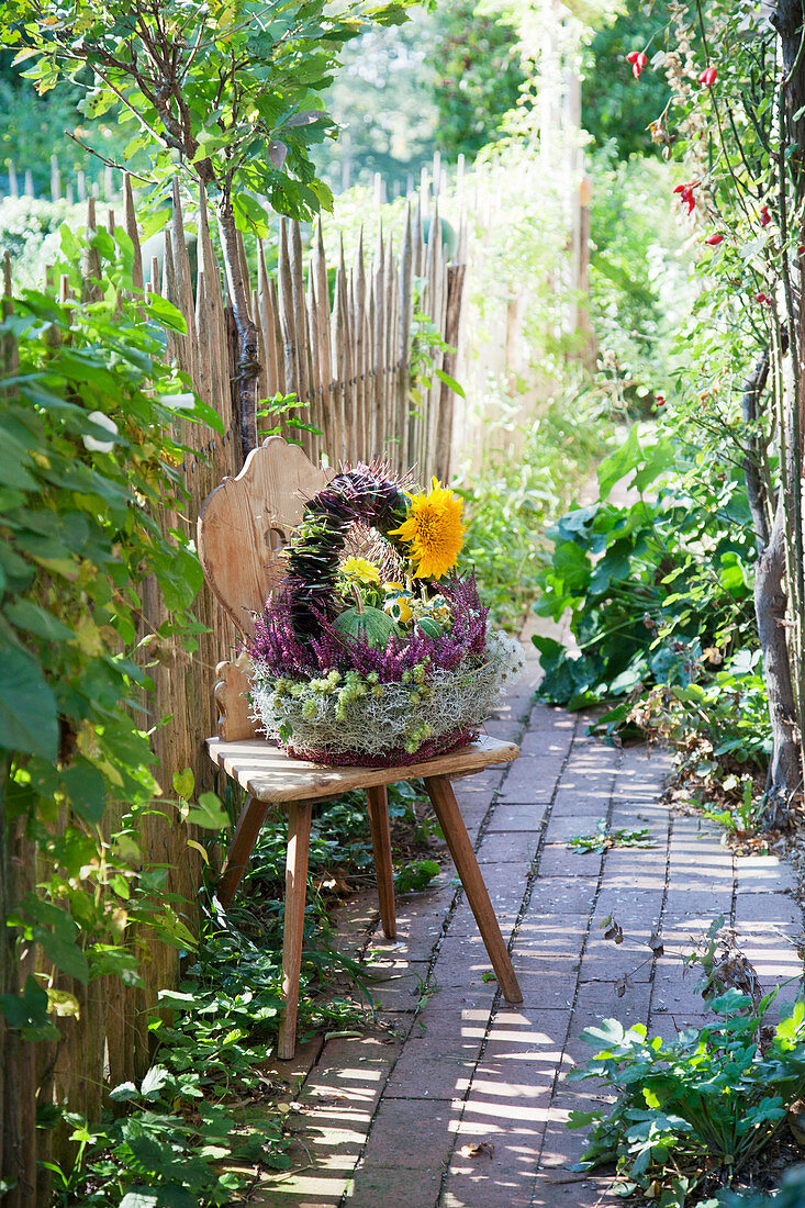 Autumn arrangement in basket with handle on farmhouse chair