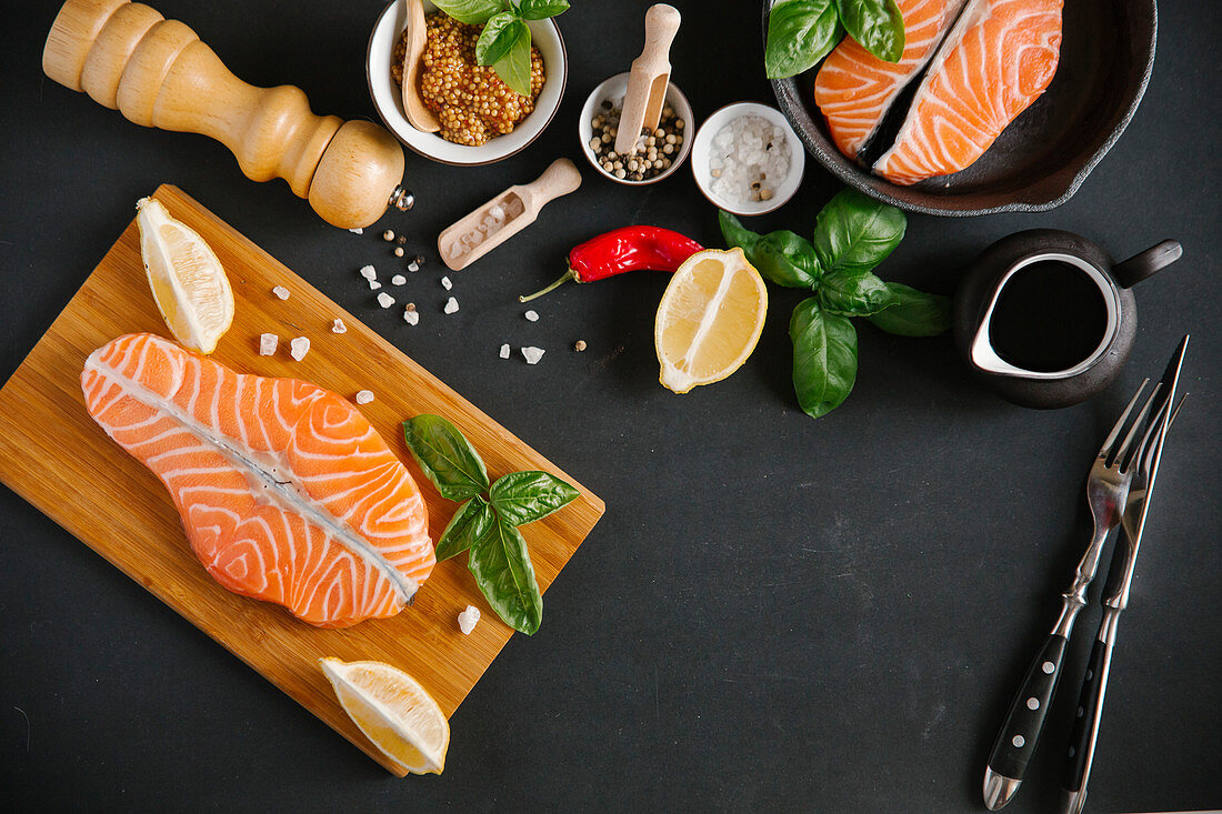 A still life with salmon, spices, basil and lemon