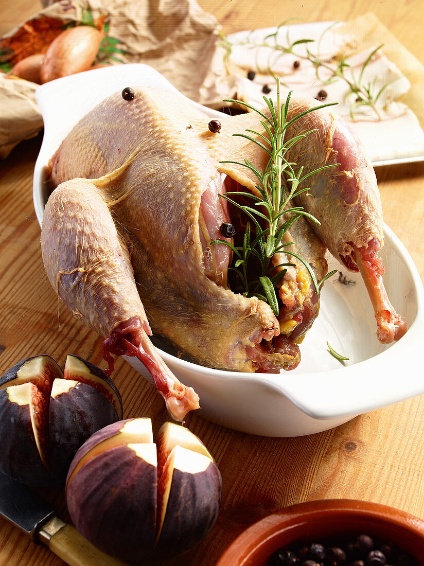 A ready-to-roast duck with ingredients, herbs and spice