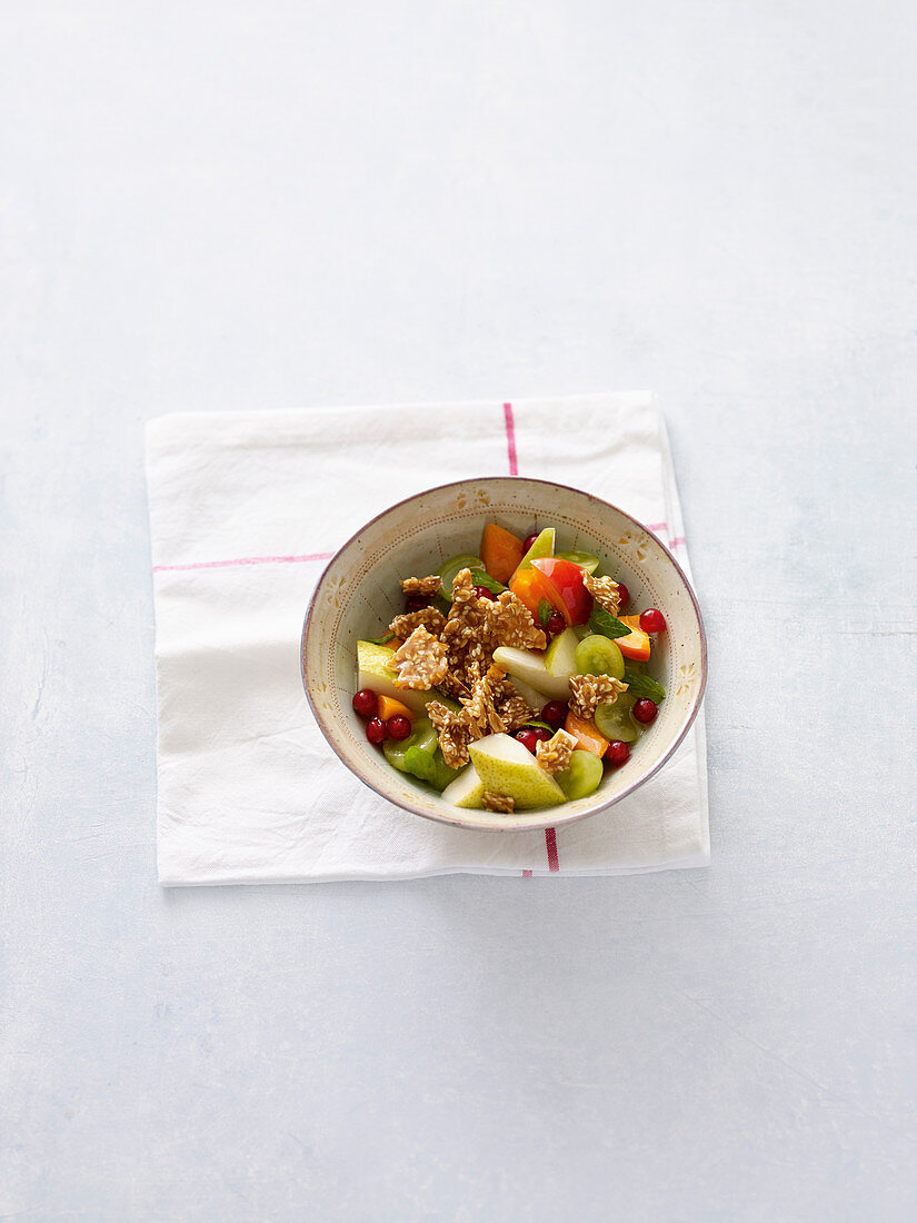 Fruit salad with oat and sesame seed brittle