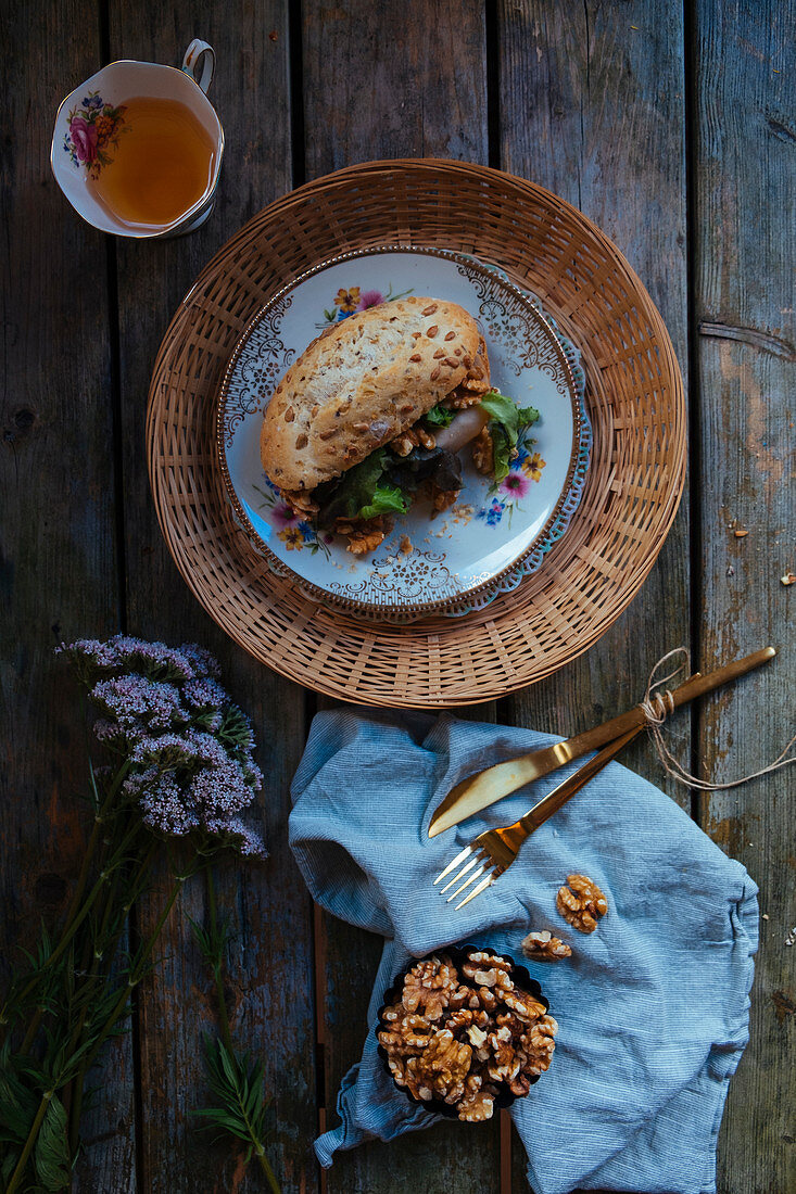 Belegtes Brötchen mit Salat und einer Tasse Tee