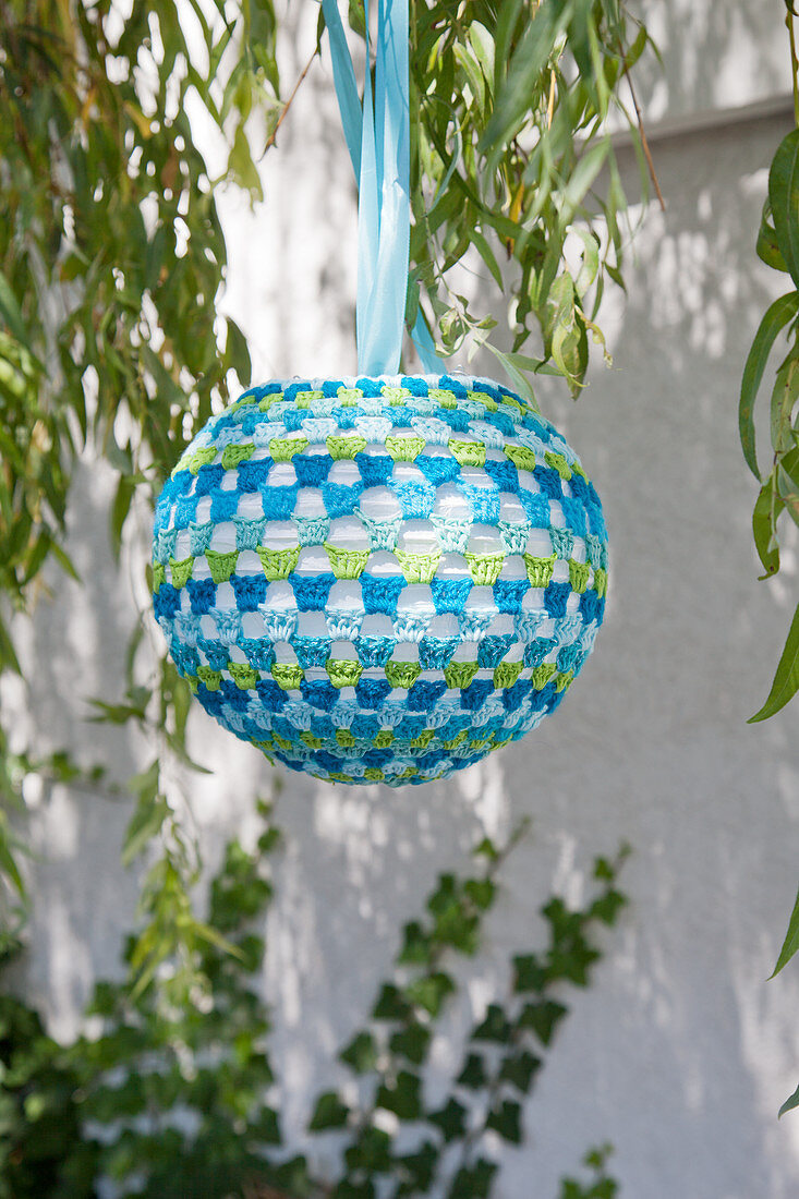 Lantern with blue and green crocheted cover