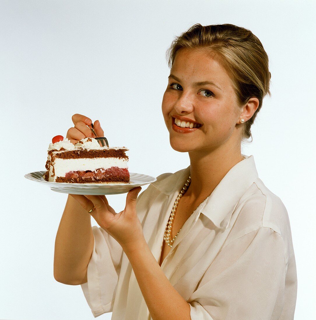 Model holding plate with piece of cherry gateau (close-up)