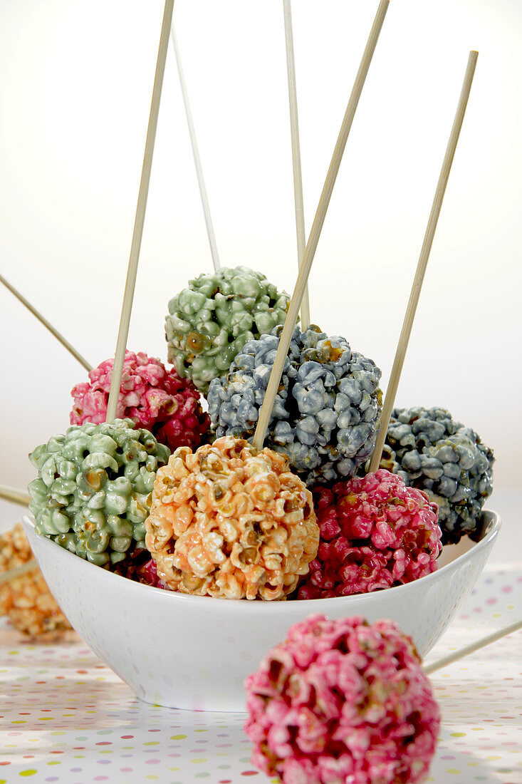 Different coloured popcorn balls on sticks