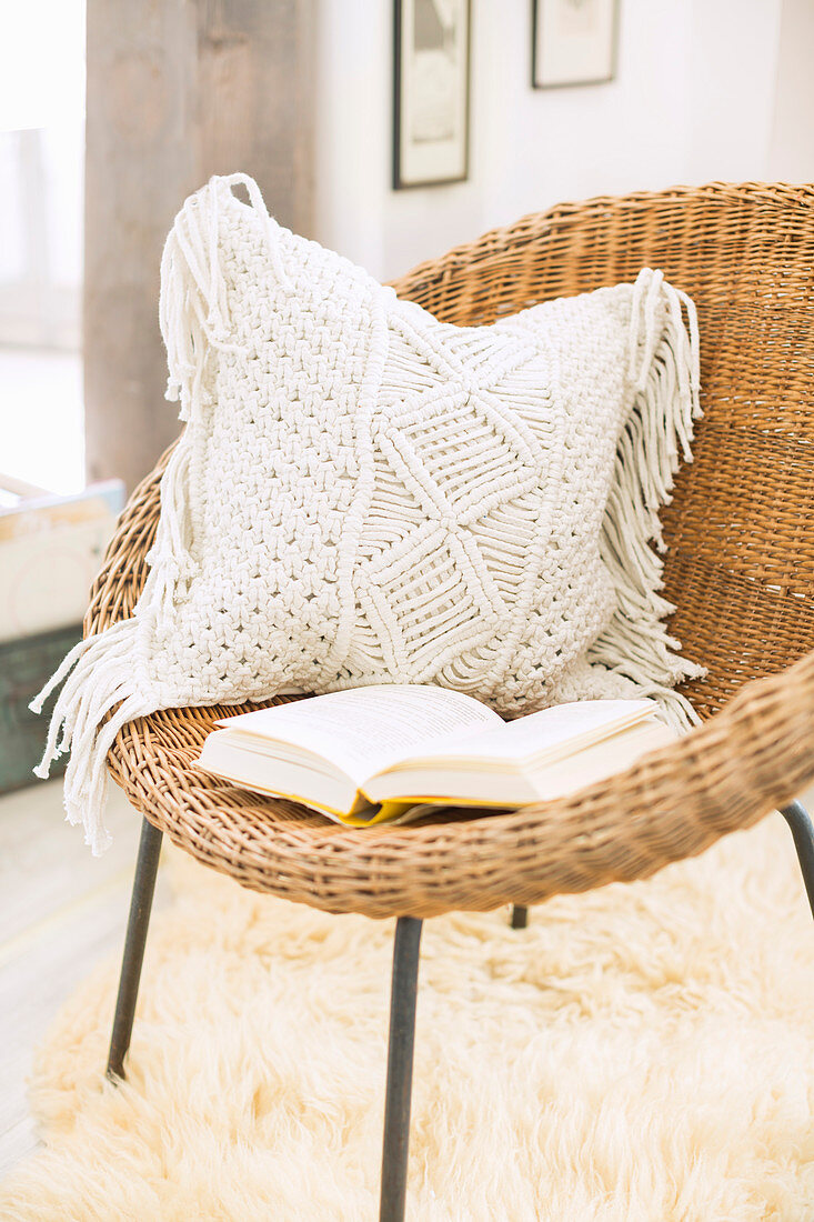 Cushion with macrame cover on wicker chair