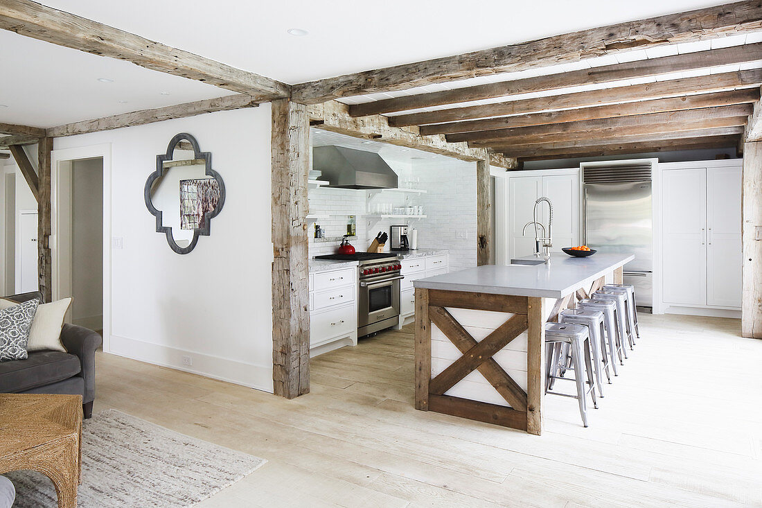 Rustic wooden beams in open-plan interior with island counter in open-plan kitchen