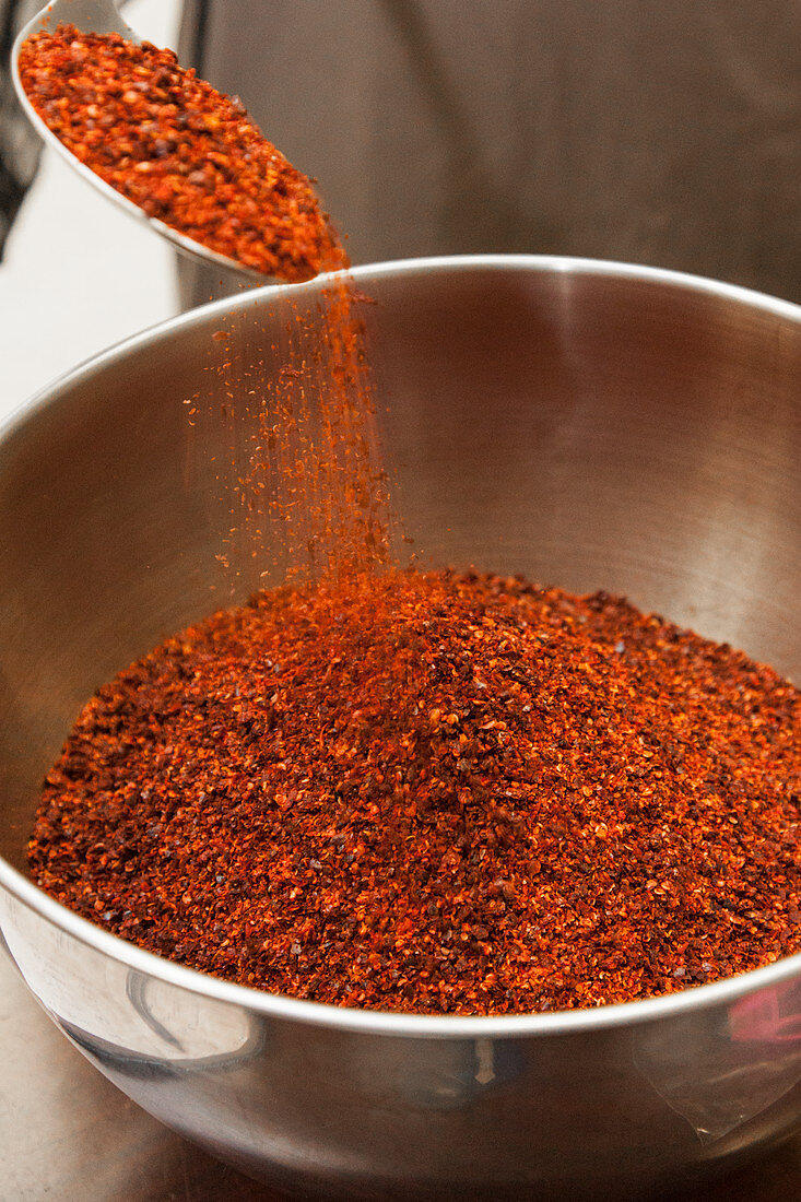 Zerstossene getrocknete rote Paprika in Metallschüssel