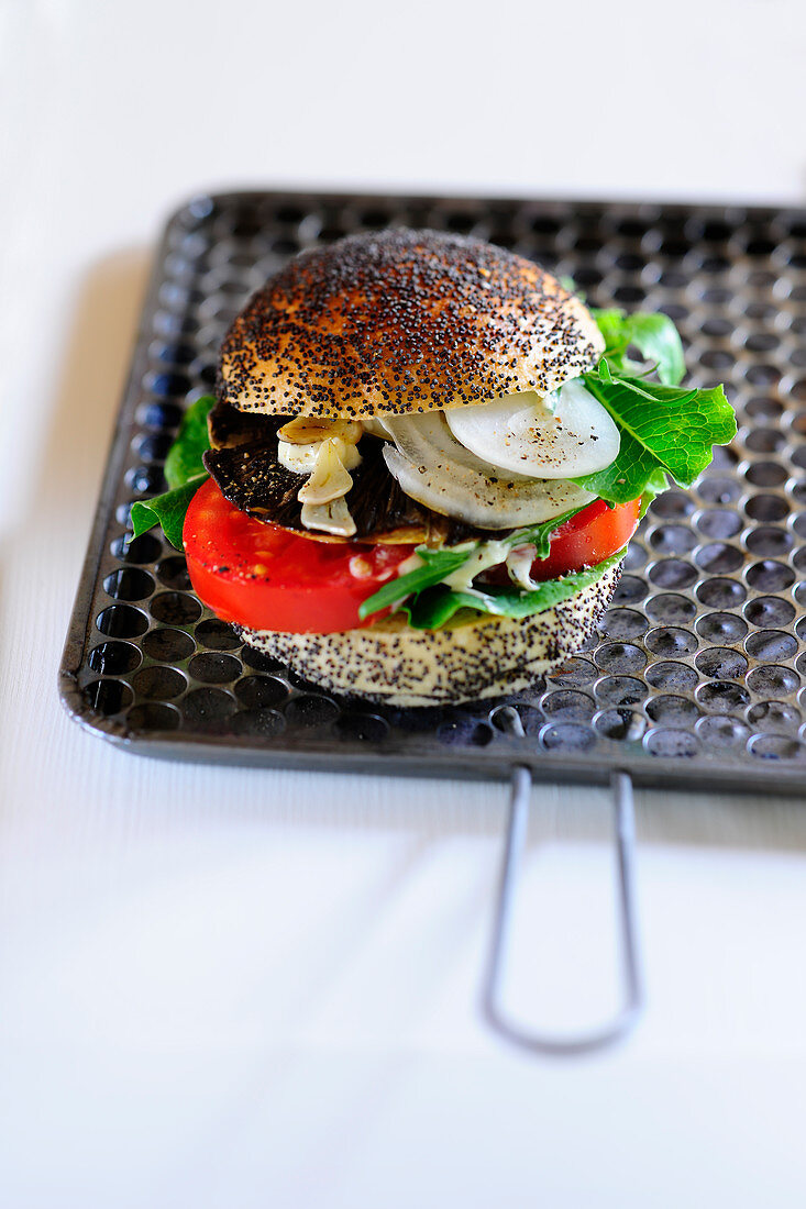 A burger with mushrooms, tomatoes and onions