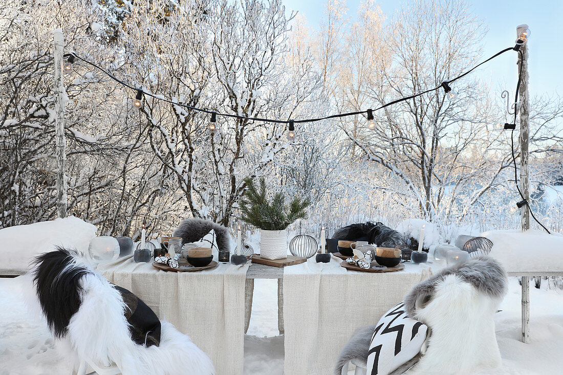 Gedeckter Tisch mit Weihnachtsdekoration im Garten