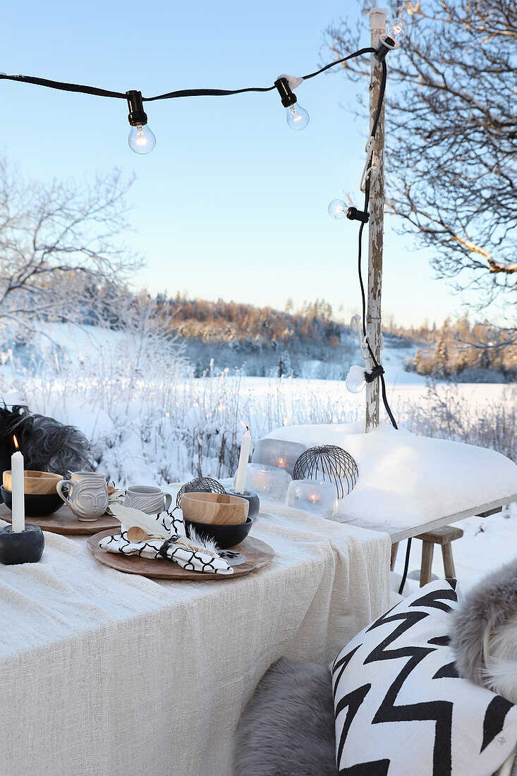 Gedeckter Tisch mit Weihnachtsdekoration im Garten