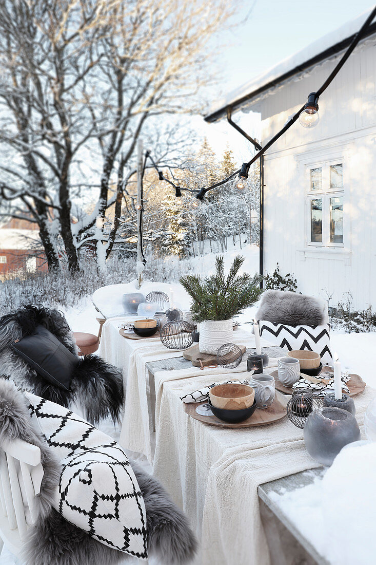 Gedeckter Tisch mit Weihnachtsdekoration im Garten