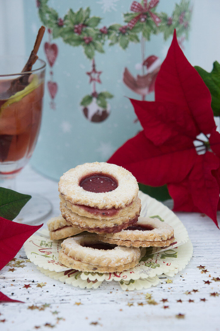 Jam sandwich biscuits, mulled wine, a tin and a poinsettia