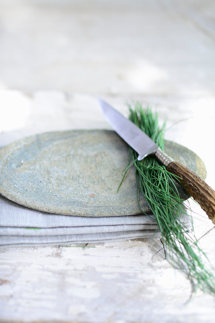Wild chives on a stone plate with a knife