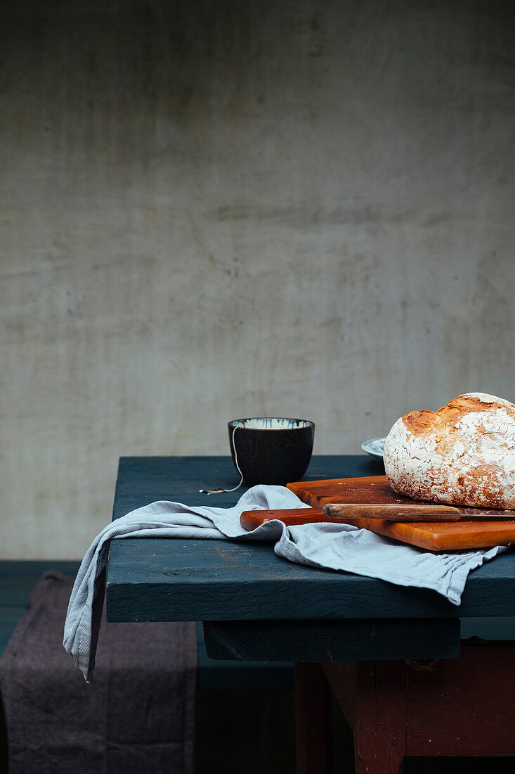 Stillleben mit Brotlaib und Teeschälchen auf Tisch