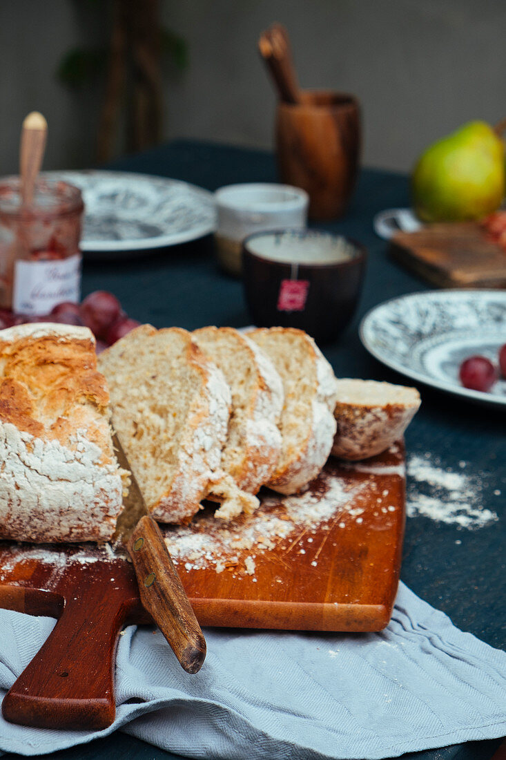 In Scheiben geschnittener Brotlaib auf Frühstückstisch