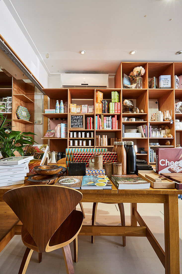 Wooden table with designer chair, shelf in the background