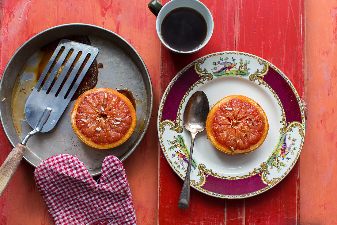 Gebratene rosa Grapefruits und Kaffee zum Frühstück