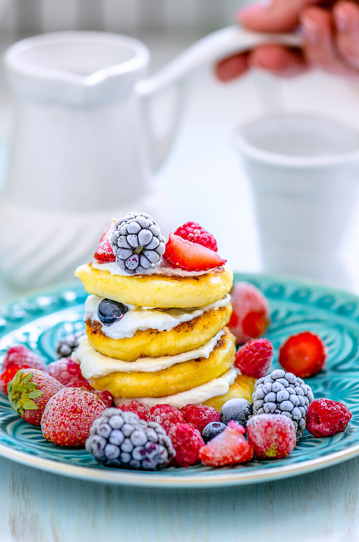 Ricotta-Pancakes mit Sahne und gefrorenen Beeren