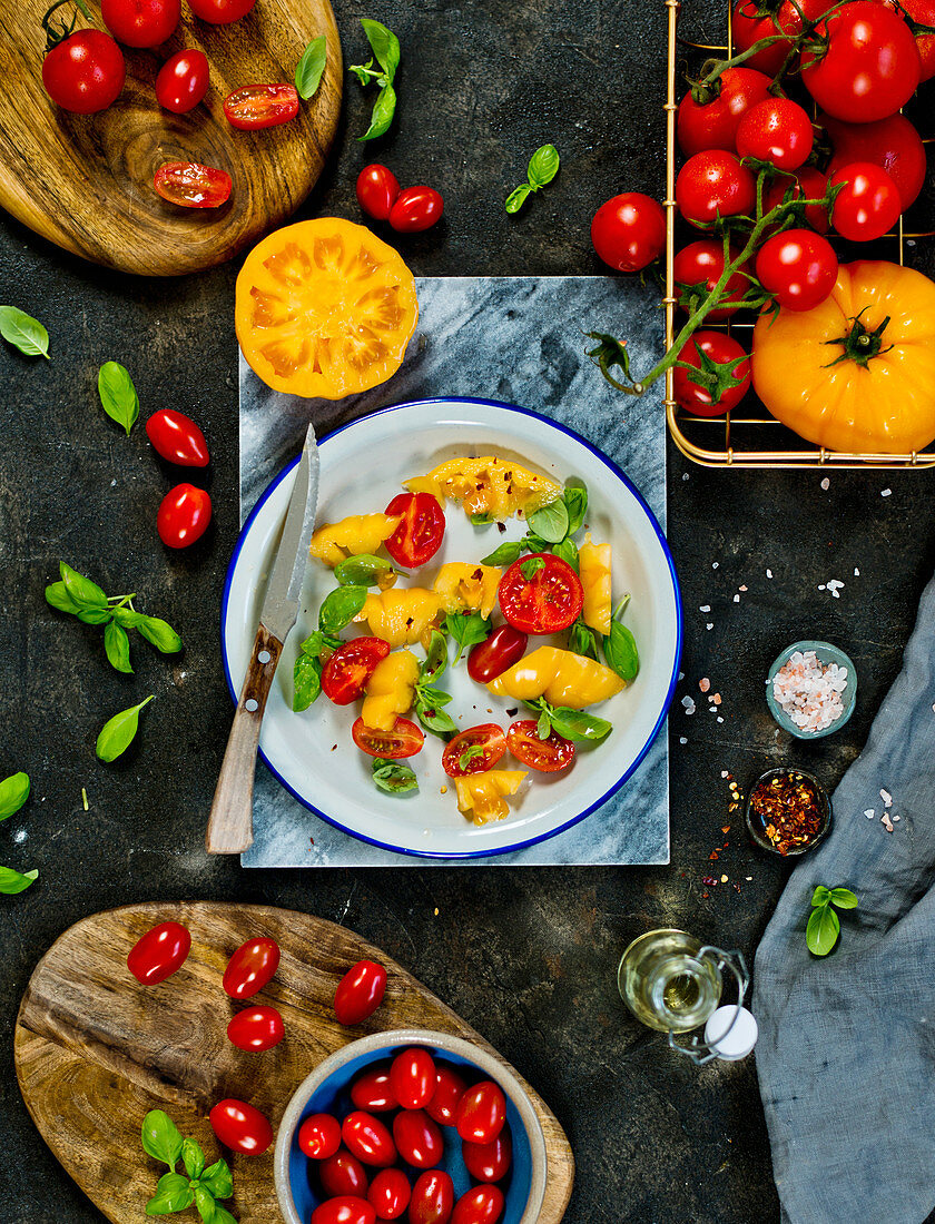 A salad of yellow and red tomatoes with basil