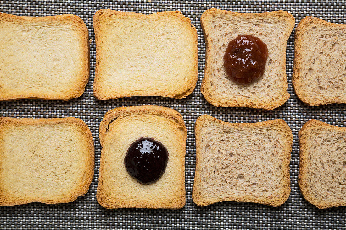 Slices of zwieback (rusk), some with jam