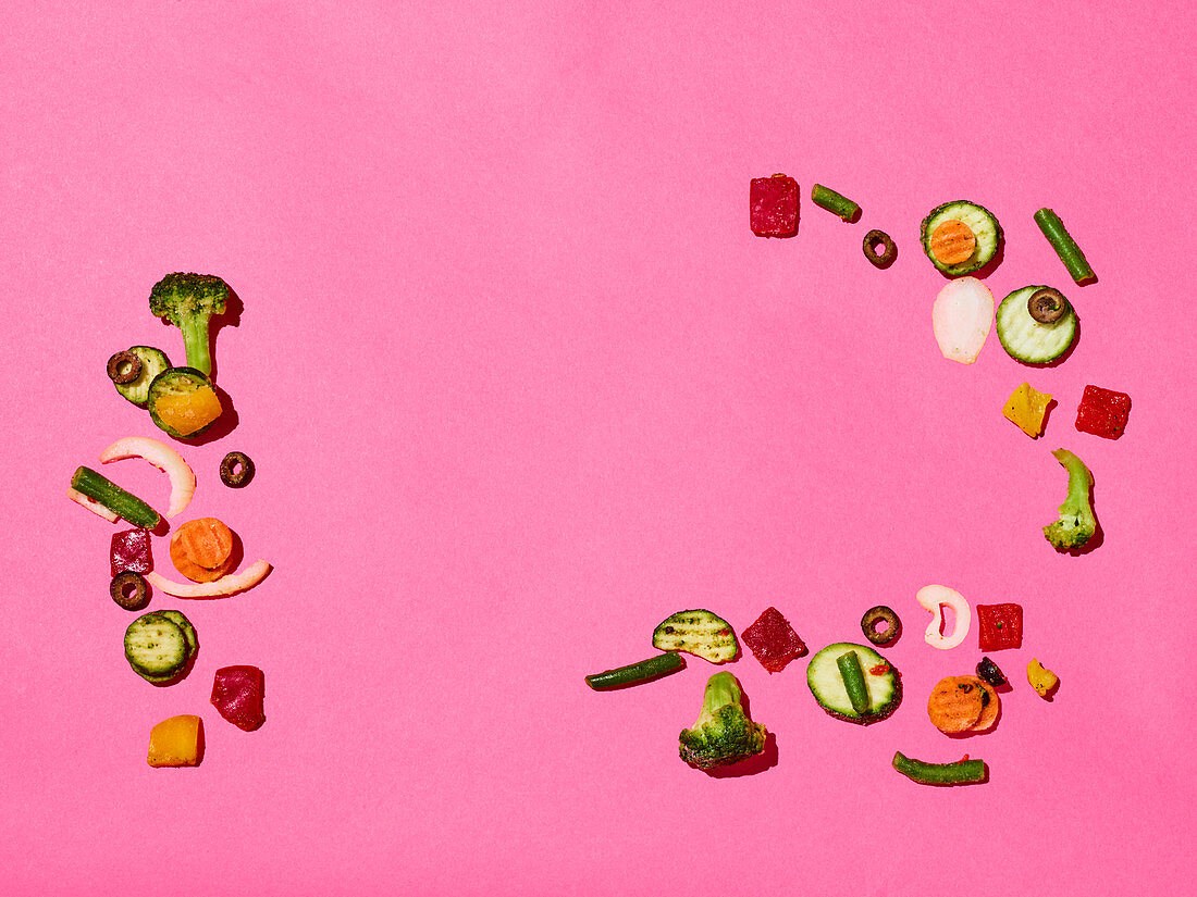 Small pieces of soup vegetables on a pink surface