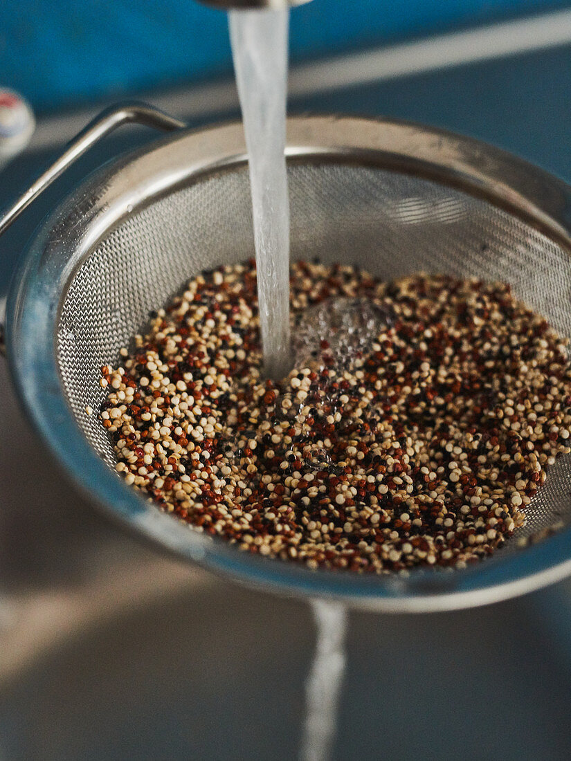 Quinoa being washed in a sieve
