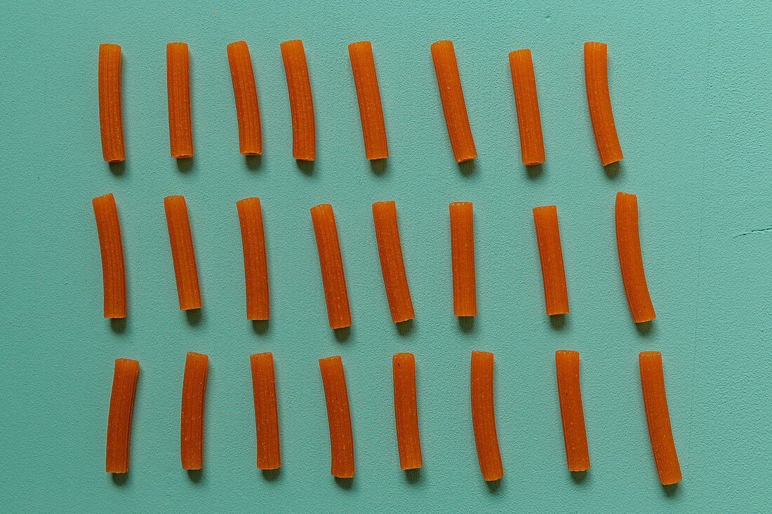 Red lentil pasta on a coloured surface