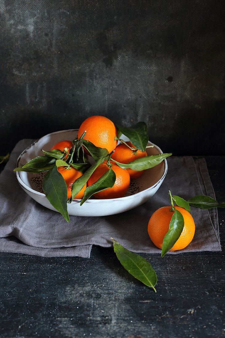 Mandarinen mit Blättern in einer Schale