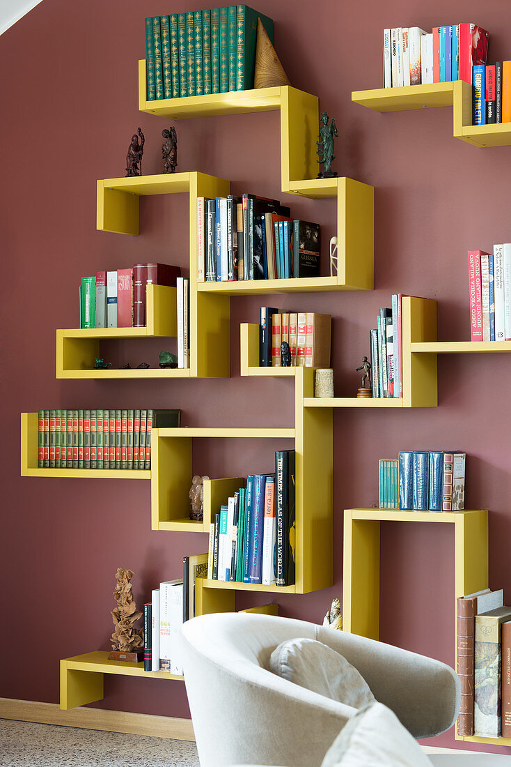 Yellow designer bookshelves on dark red wall