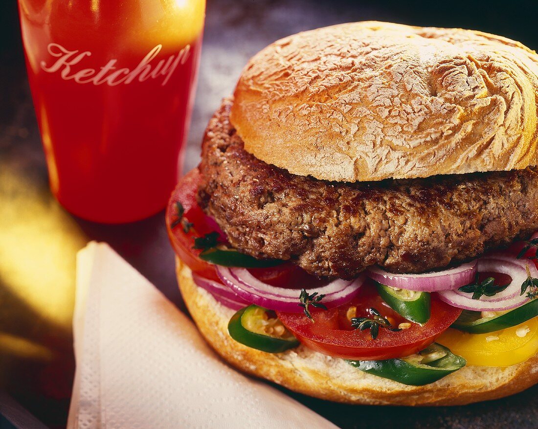 Ein Hamburger mit roten Zwiebeln, Tomate, Peperoni & Ketchup