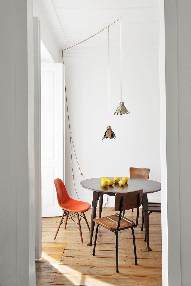 Round table and various chairs on wooden floor